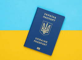 Ukrainian Biometric Passport On A Yellow Blue Background Of The Flag Of Ukraine. Migration, Travel Concept